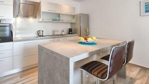 A modern kitchen with a central island, stainless steel appliances, and a fruit bowl. - Awesome home in Liznjan (Liznjan)