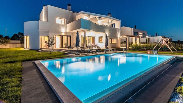 A modern two-story house with a swimming pool, outdoor seating, and a well-lit patio area. - Stunning home in Porec with sauna (Porec)