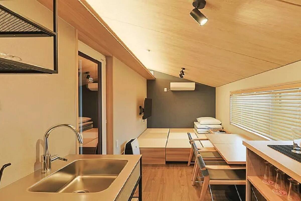 A compact kitchen with a sink, countertop, and a refrigerator.