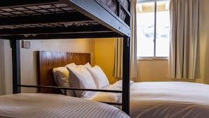 A bunk bed room with two beds, a wooden headboard, and a window with curtains. - Eiger Chalet (Perisher Valley)