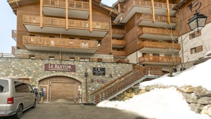 Ein mehrstöckiges Holzgebäude mit Balkonen, einer Steinaußenfassade und einem Schild, das es als Residenzhotel kennzeichnet.