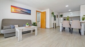 Una sala de estar moderna con un sofá, una mesa de centro y un comedor con sillas.