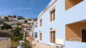 Un edificio con un letrero con su nombre, una escalera y vistas del entorno.