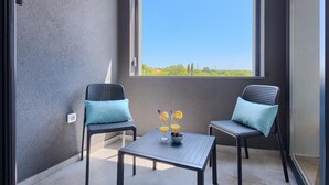 A balcony with two chairs and a table, a small vase with flowers, and a bowl of fruit. - Gorgeous home in Pula (Pula)