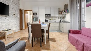 A modern kitchen with white cabinets, a microwave, and a dining area with a table and chairs. - Apartment "La Casa di Faby" with Balcony and Wi-Fi (Palermo)