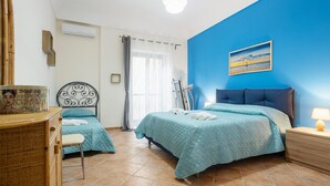 A bedroom with two beds, a desk, a chair, a lamp, and a painting on the wall. - Apartment "La Casa di Faby" with Balcony and Wi-Fi (Palermo)