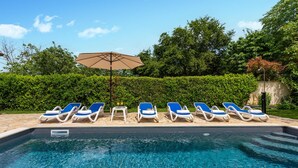 A swimming pool with blue lounge chairs and a table with drinks. - Nice home in Svetvincenat (Svetvincenat)