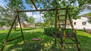 A wooden swing set in a grassy backyard with a house in the background. - Nice home in Svetvincenat (Svetvincenat)