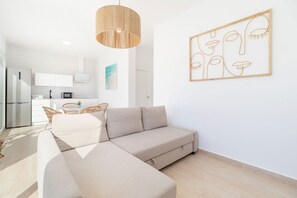 Ein modernes Wohnzimmer mit einem Ecksofa, einer Pendelleuchte und einem Wandbild.