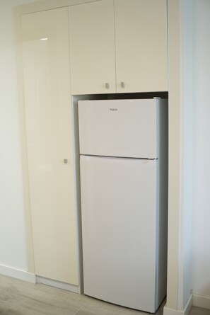 A white TEKA refrigerator in a kitchen with white cabinets and a light-colored floor. - Holiday Apartment 'En Playa De Las Americas' with Shared Pool, Private Terrace and Wi-Fi (Playa de Las Americas)