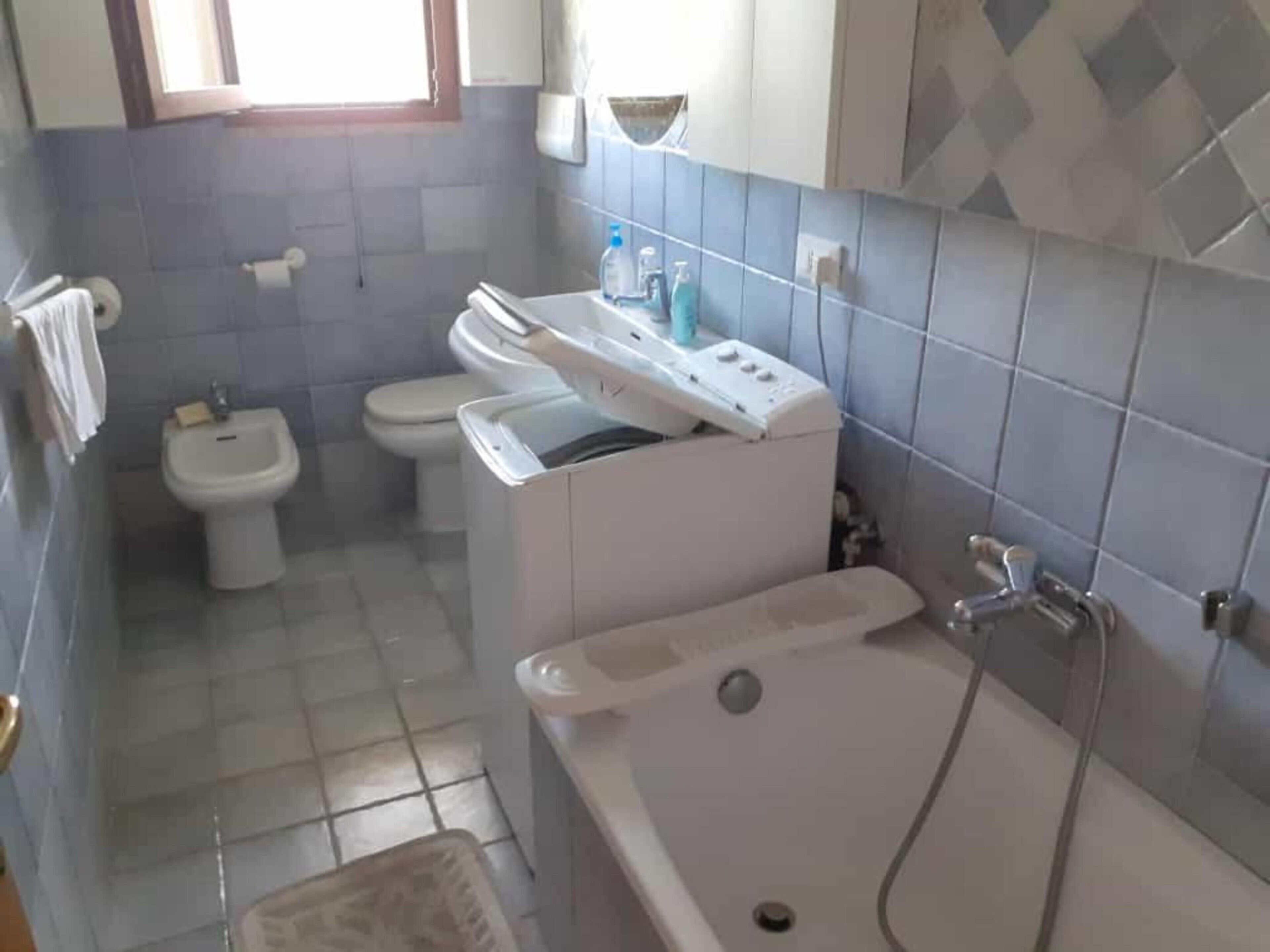 A bathroom with a bathtub, a bidet, a toilet, and a sink.