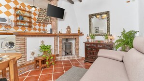 A living room with a fireplace, a television mounted on the wall, and a sofa.
