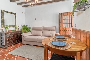 Un coin repas avec une table en bois, deux assiettes bleues et un verre de vin.