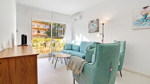 A living room with a sofa, a coffee table, and a balcony with outdoor furniture. - Apartment "Brisas C2" with Shared Pool & Wi-Fi (Denia)