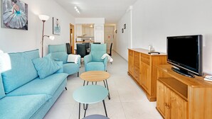 A living room with a sofa, two armchairs, a coffee table, a TV, and a wooden cabinet. - Apartment "Brisas C2" with Shared Pool & Wi-Fi (Denia)