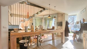 Een moderne keuken met een centraal eiland, hanglampen en uitzicht op de omgeving.