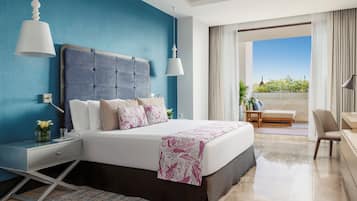 A modern hotel room with a large bed, a nightstand, a desk, and a view of the outdoors.