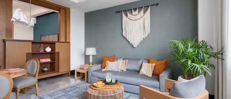 A modern living room with a grey sofa, wooden sideboard, and a round coffee table.