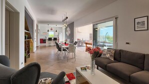 Un salon moderne comprenant un canapé, une table basse et un coin repas avec des chaises et une table.