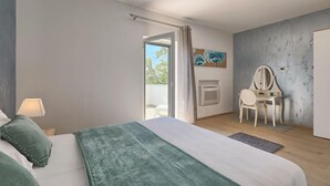 Une chambre à coucher avec un lit, un bureau doté d’un miroir, une cheminée et une vue sur l’extérieur, visible à travers une porte.