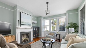 A living room with a fireplace, a television, and a comfortable seating area. - Pet-Friendly +Historic Charm & Modern Comfort Near Upper King (Charleston)