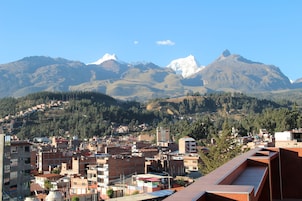 Uma cidade com edifícios e uma cordilheira ao fundo.