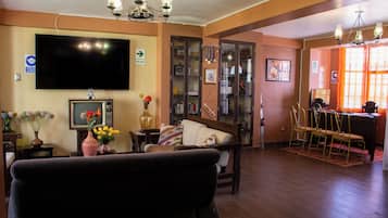 Una sala de estar con un sofá, televisor y adornos decorativos.