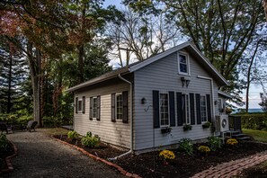 Een gelijkvloers huis met een zadeldak, een voortuin en een kleine tuin met gele bloemen.