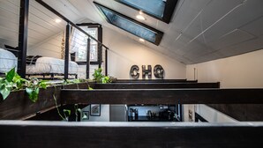 Een slaapkamer in loftstijl met een stapelbed, dakraam en een kitchenette.