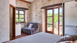 A cozy room with a bed, a small desk, and a window overlooking greenery. - Gorgeous home in Pula (Pula)