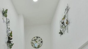 A staircase with white railings and a granite floor, leading to a room with a white ceiling and a decorative mirror. - Hotel Grand Caribe (San Andrés)