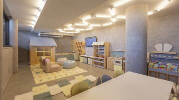 Children can play and learn in this spacious room with a large play table, comfortable seating, and educational resources.