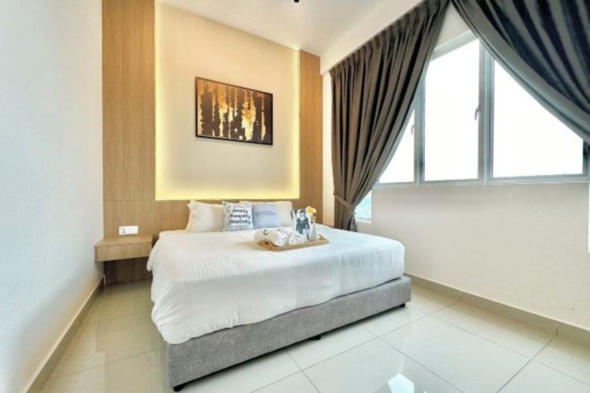 Habitación de hotel moderna con una cama grande, una mesita de noche, una obra de arte colgada en la pared y una ventana con cortinas.