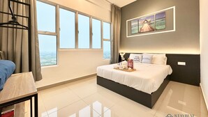 A modern hotel room with a large bed, a ceiling fan, a view of the city, and a framed picture on the wall. - Amber Cove Melaka Sea View by Stayrene (Malacca City)