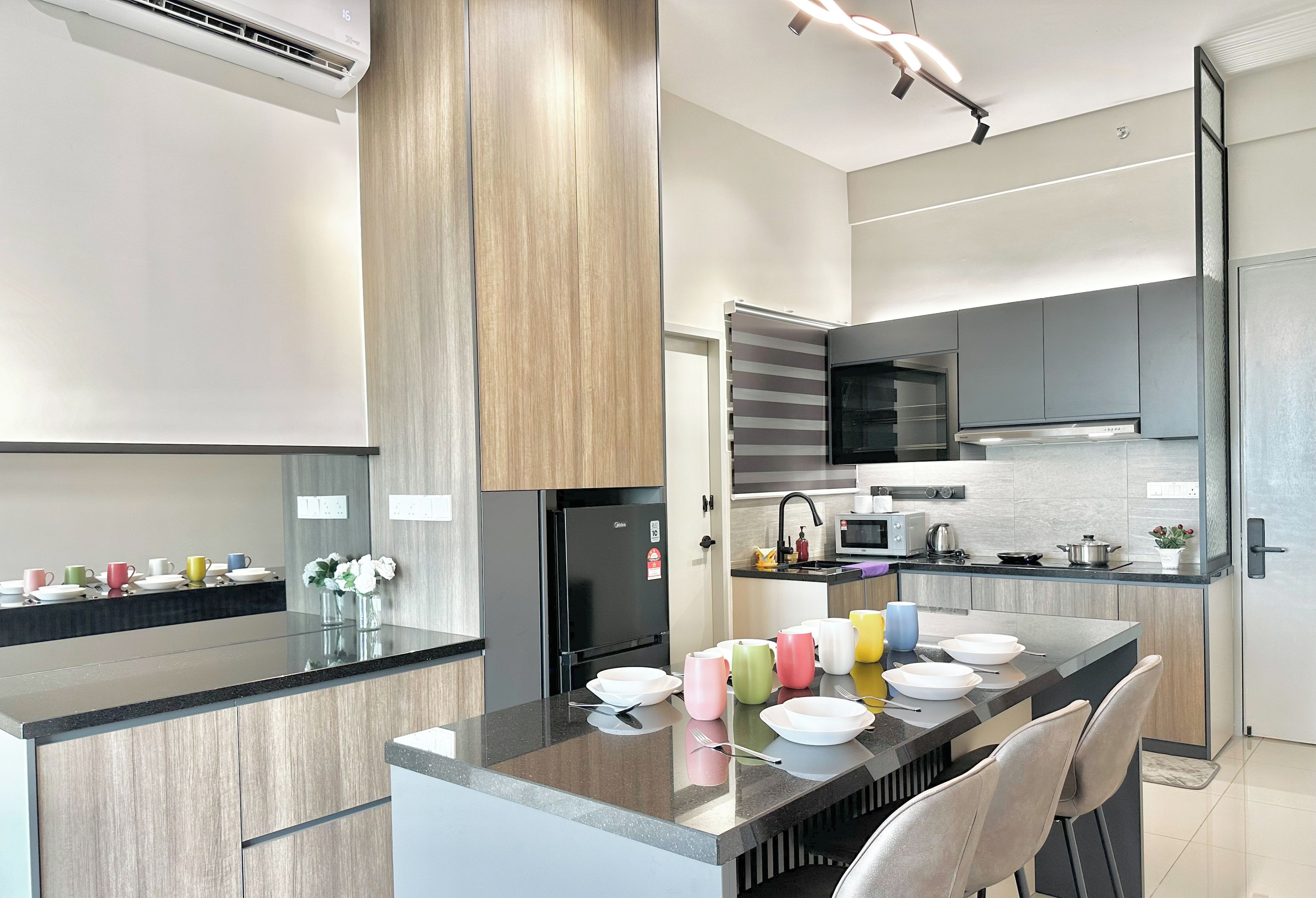 A modern kitchen with a central island, built-in appliances, and a dining area with bar stools.