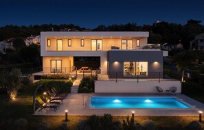 Relax by the pool surrounded by a well-maintained garden and comfortable outdoor seating.