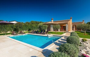 Ein Poolbereich mit Liegestühlen und einem klaren, blauen Pool.