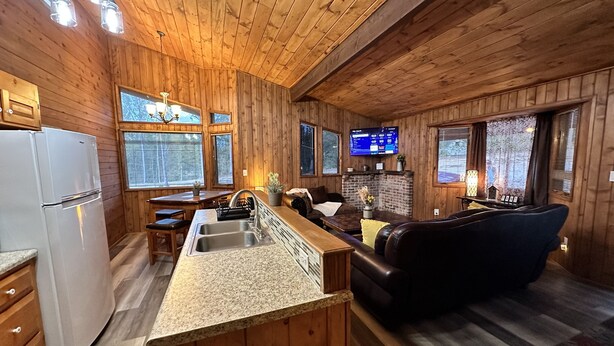 A wooden cabin interior with a kitchen, dining area, and living room. - Cozy 2br Bear Den Cabin in Campobello SC, on the upcoming Saluda Grade Trail. (Campobello)