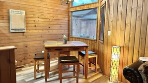 A wooden interior with a dining table, chairs, a small potted plant, and a lamp. - Cozy 2br Bear Den Cabin in Campobello SC, on the upcoming Saluda Grade Trail. (Campobello)