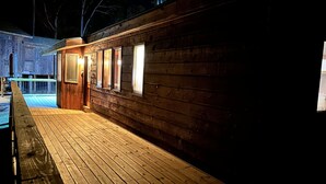 A wooden building with a deck, windows, and a door. - Cozy 2br Bear Den Cabin in Campobello SC, on the upcoming Saluda Grade Trail. (Campobello)