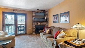 A living room with a fireplace, a sofa, a coffee table, and a lamp.