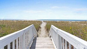 A wooden boardwalk leading to a beach with a clear sky. - Zion of Holden by Brunswick Vacation Rentals: 5BR Oceanfront w/ Pool & Views (Holden Beach)
