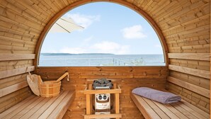 Una sauna de madera con un banco, un banco con una toalla y un cabezal de sauna.