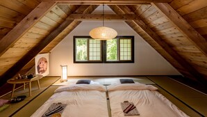 Ein traditioneller japanischer Raum mit Tatami-Bodenbelag, niedriger Holzzieldecke und einem Fenster mit Shoji-Bildschirmen.