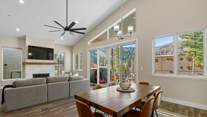 A spacious living area with a wooden dining table, a sofa, and a ceiling fan. - The Liftview: 3BR home at Purgatory Resort (Durango)