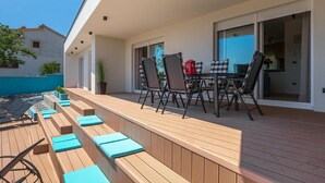 An outdoor deck with wooden benches and a table with chairs. - Pet friendly home in Pula (Pula)