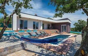 A modern house with a swimming pool, outdoor seating, and a view of the sea. - Pet friendly home in Pula (Pula)