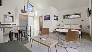 Un espacio habitable moderno y abierto con cocina, comedor y dormitorio.