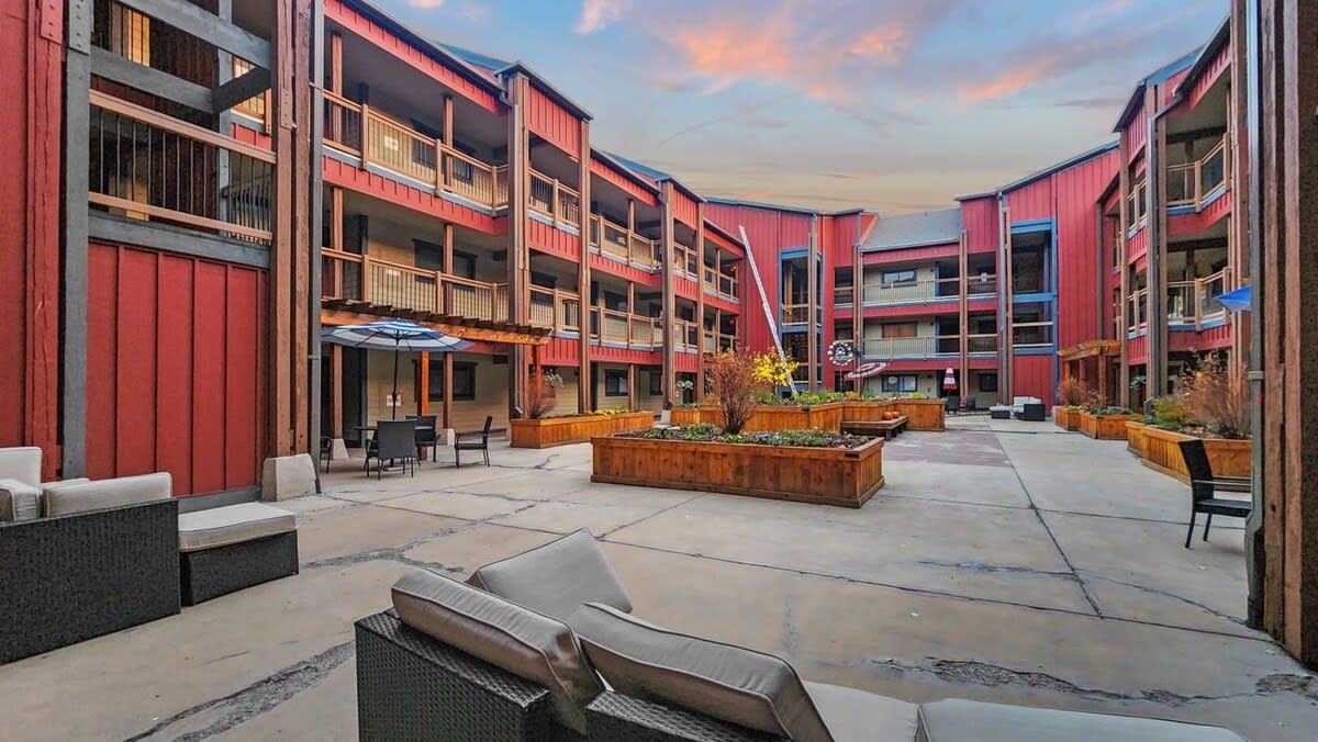 A multi-story building with outdoor seating areas and planters.