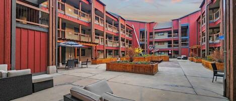 A multi-story building with outdoor seating areas and planters.
